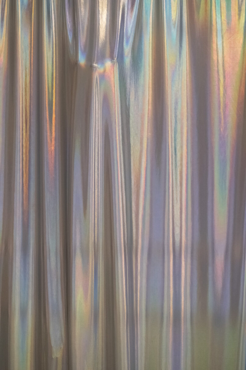 shiny textile surrounds a metal structure in a large gallery.