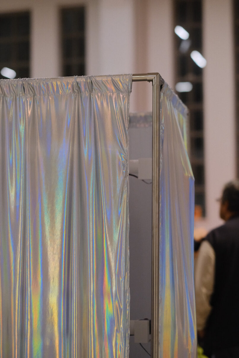 shiny textile surrounds a metal structure in a large gallery.