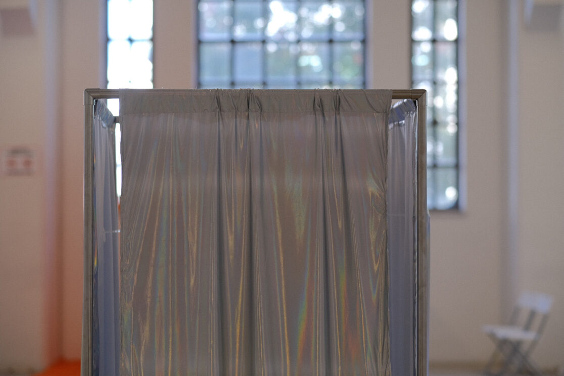 shiny textile surrounds a metal structure in a large gallery.